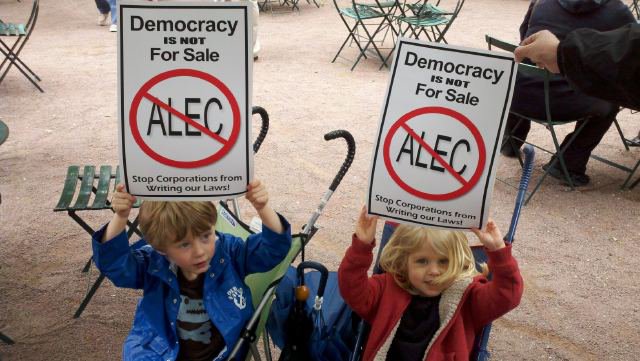 Kids in Cincinnati holding signs protesting ALEC