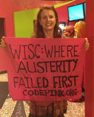 As Walker addressed the RNC, Jodie Evans unfurled this sign.