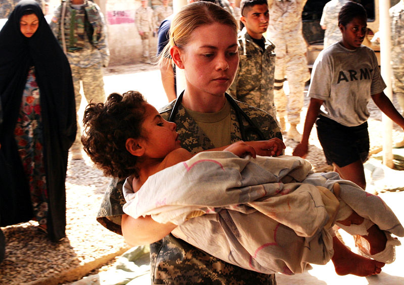 U.S. soldier carries a wounded Iraqi child (Marine Corps photo)