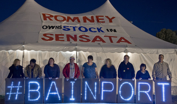 workers holding letters that say "#bainport" in front of a large tent