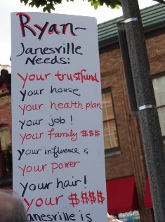 Sign at recent protest in Janesville. Photo courtesy of Karen Kinsley.