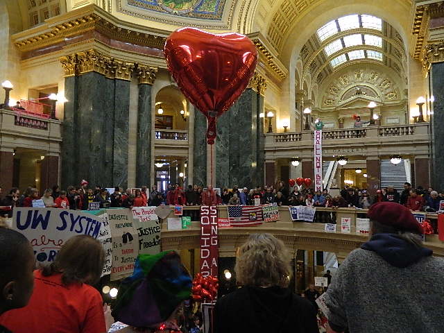 A heart balloon with a crowd in the background in the Capitol.