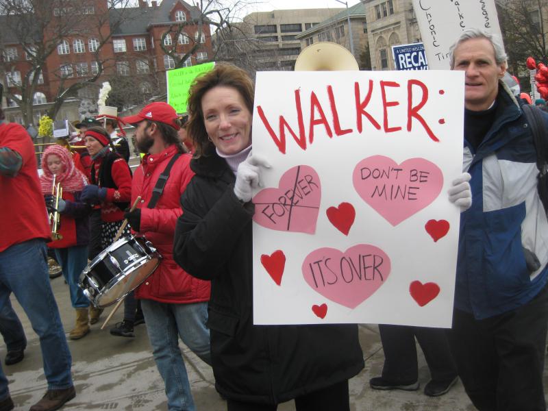 Woman holding sign with break-up valentine's message for Walker